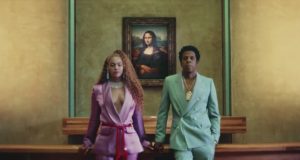 A still from the music video of The Carters' Apes**t showing Beyonce and Jay-Z posing in front of Leonardo Da Vinci's Mona Lisa at the Louvre