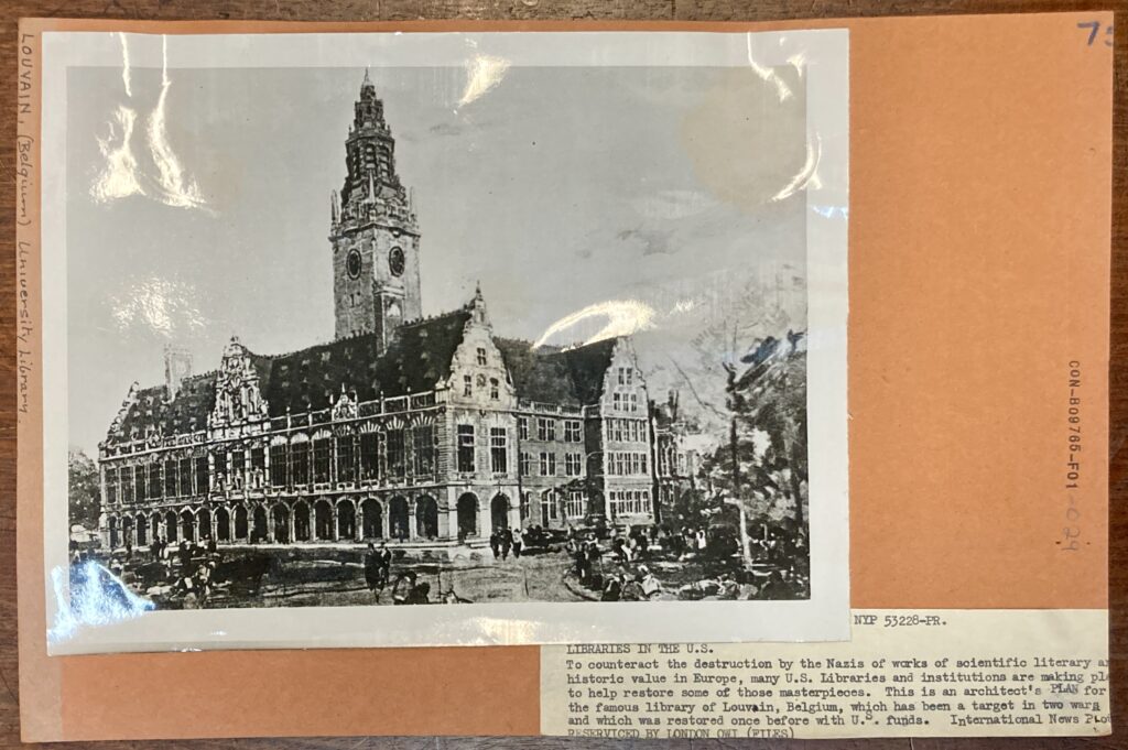 An old black and white photo of the plans for the Louvain Library, a gothic style building that looks somewhat like a church. The photo is stuck on an orange card mount with some typewritten text. 