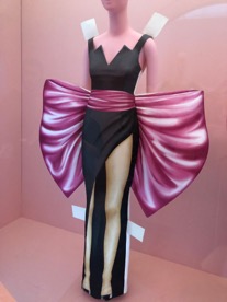 Mannequin wearing black dress with pink bow wrapped around the waist.
