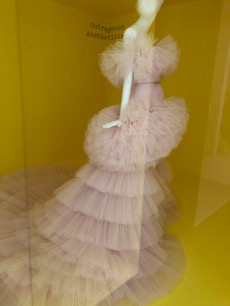 Mannequin wearing light pink dress with layers of tulle.