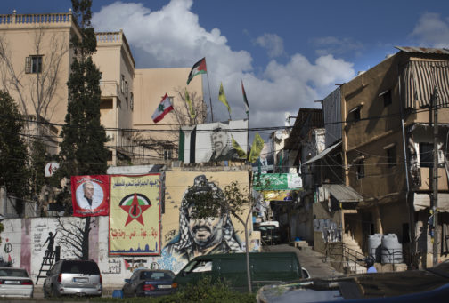 Image of street in Beirut with portraits of man and flags on old buildings