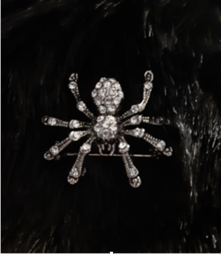 Close up of diamond spider brooch pinned to black fabric