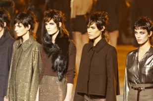 Three models in a line on a runway with mullets.