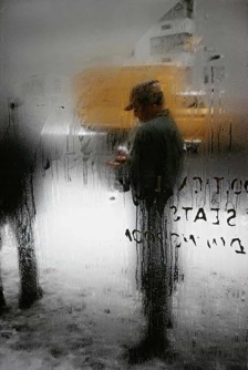 Man through frosted window with writing on it 