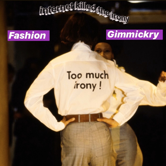 The behind profile of a woman dressed in a white shirt with the slogan "Too much irony" printed across her back