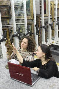 two female students examining athos cross in store