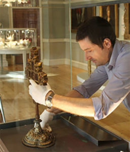 a man installing the mount athos cross on a plynth in the Courtauld's Gallery