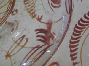 Detail of the reverse of the dish showing a pre-firing smudge of the lustre