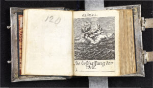 open miniature bible showing an engraving illustration from the genesis book