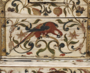 detail of a red macaw decoration on ivory casket