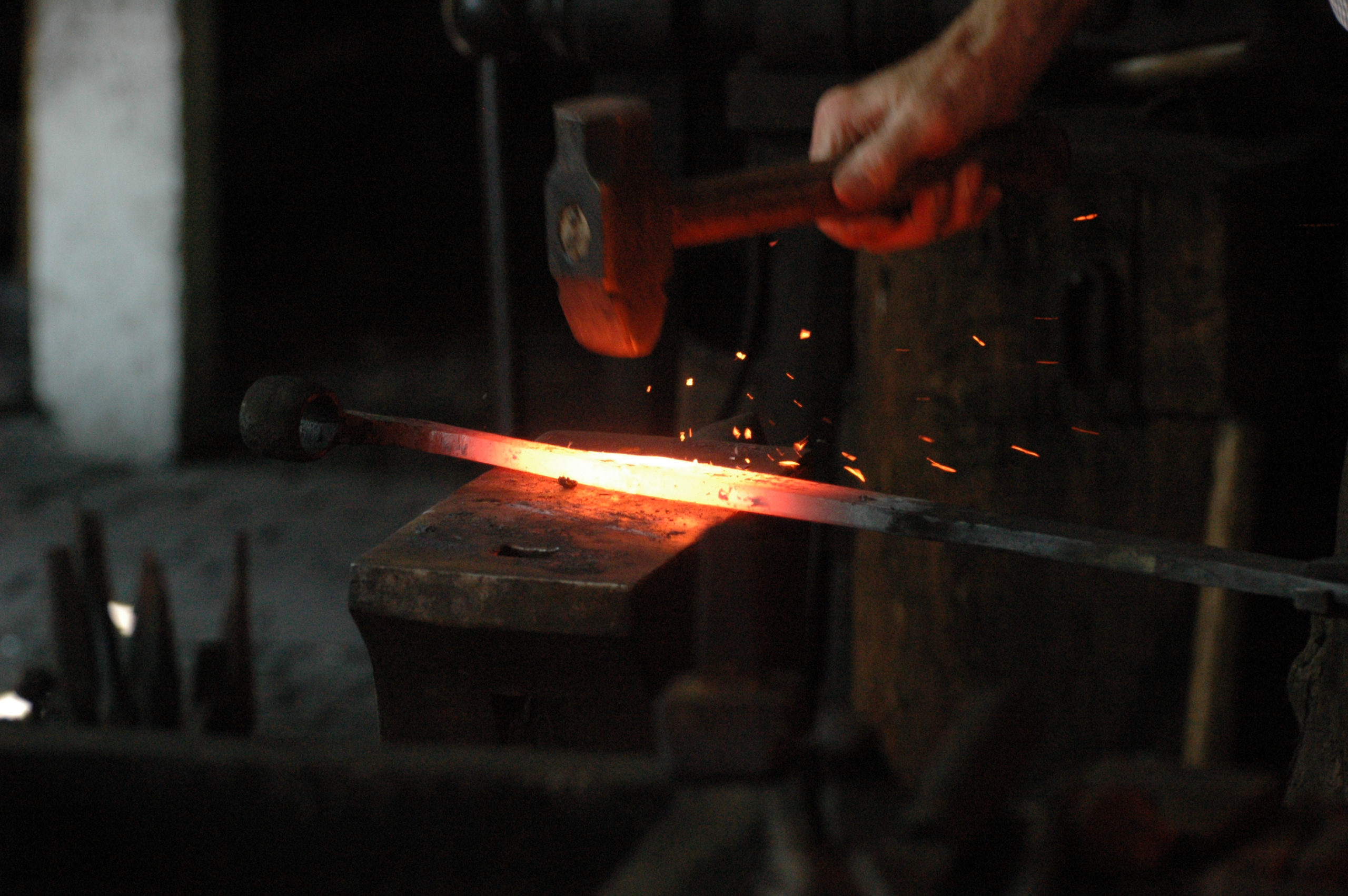 Red hot wrought iron hammered by blacksmith