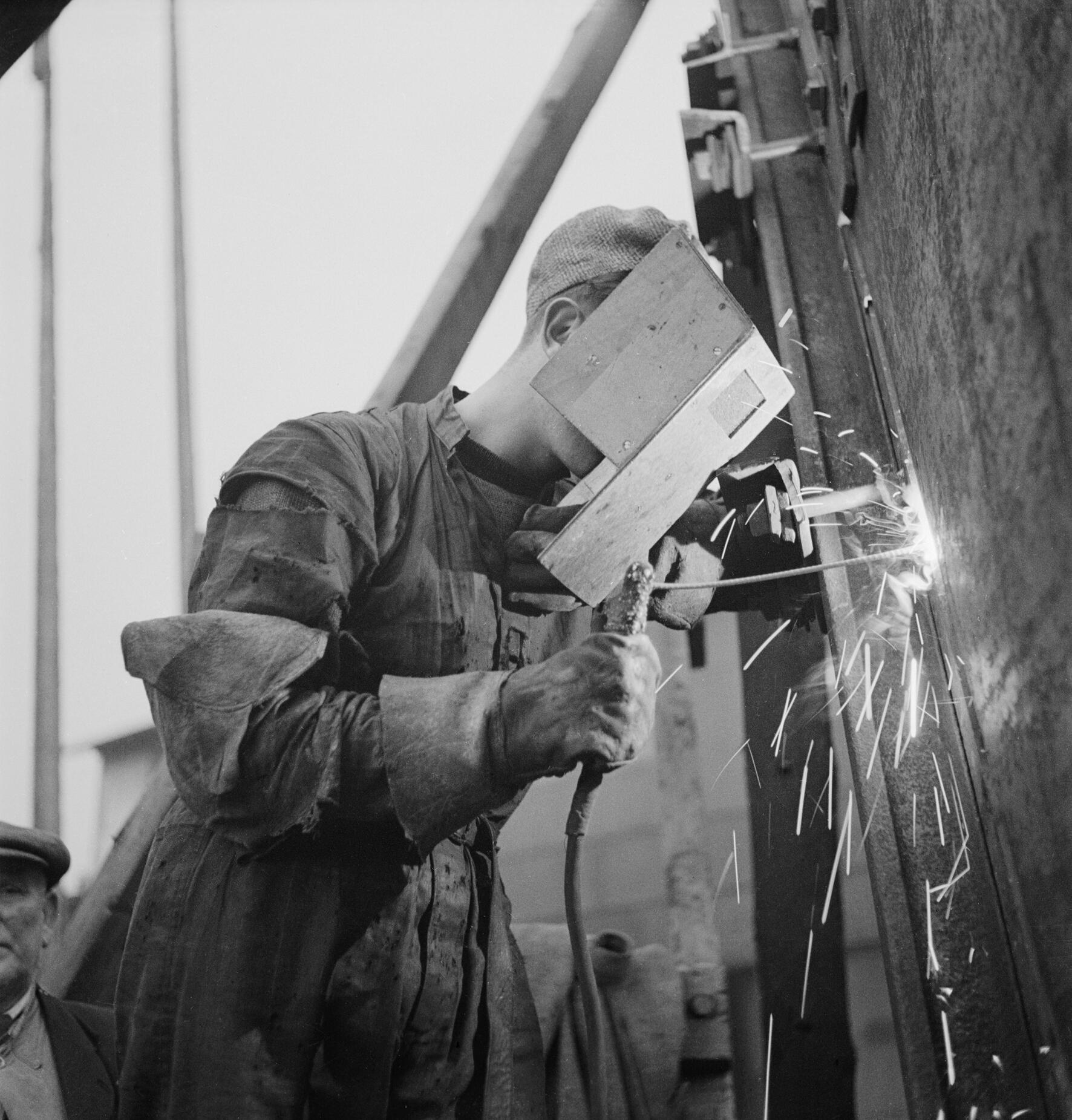 A welder working on a ship during WW2