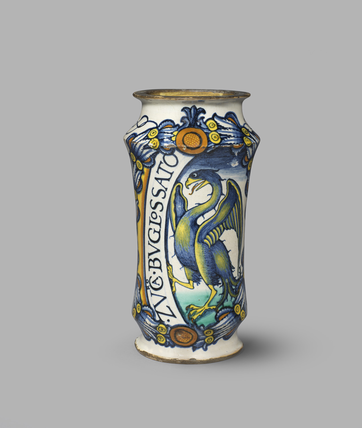 A pharmacy jar preserving bugloss, a type of herb. The jar has a blue and yellow colour scheme and has an eagle and an inscription painted on the front.