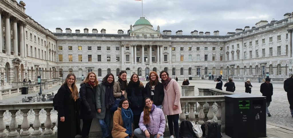 The nine curators standing in front of Somerset House, smiling at the camera.
