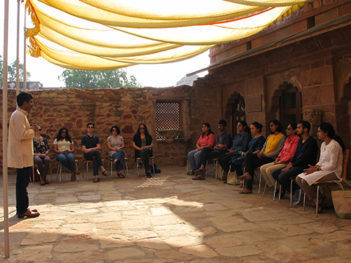 Sreekumar Menon giving a speech outdoors to a group of students