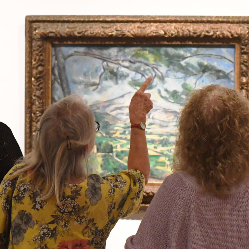 three women looking at a Cezanne painting