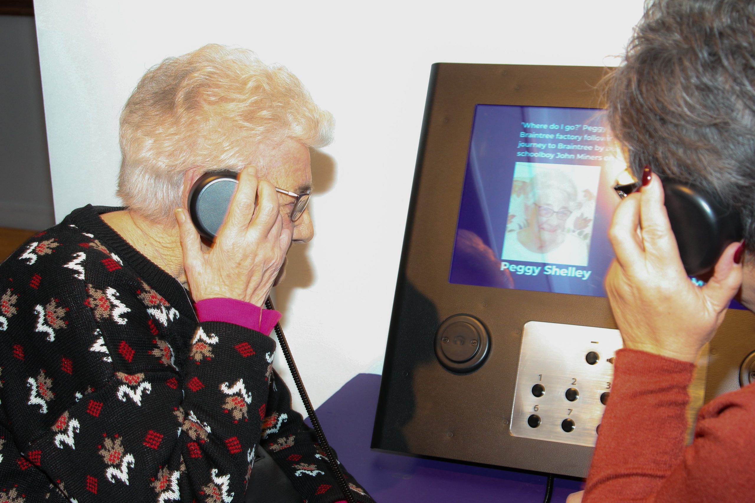 A former Courtaulds employee listens to an audio display