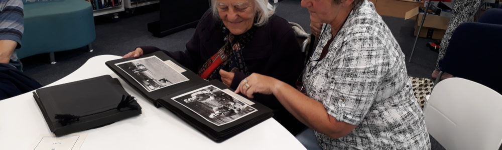 A volunteer discussing Courtauld memories with a visitor in library